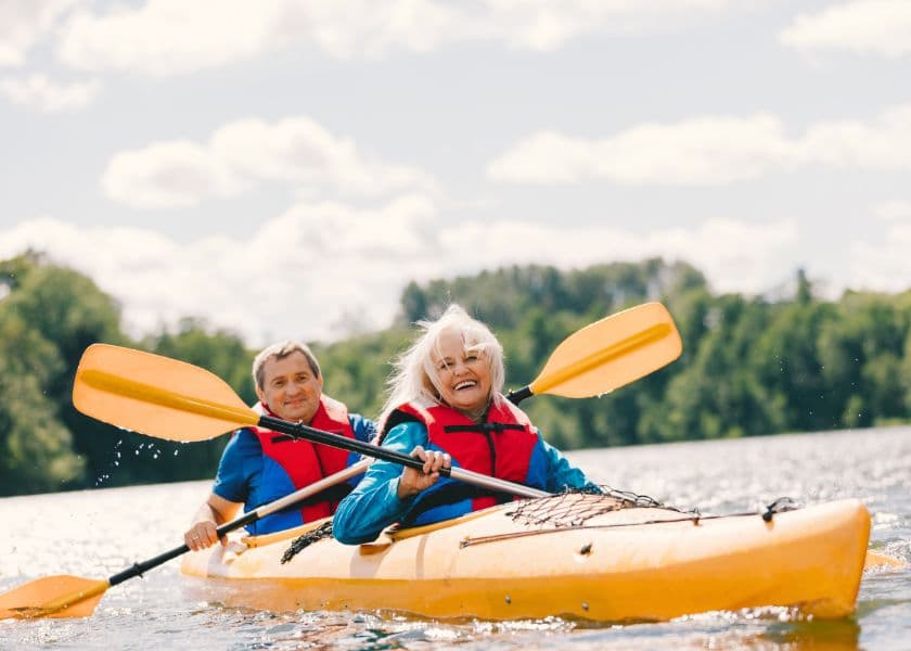 A man and a woman joyfully kayak together on a sunny lake. A man and a woman joyfully kayak together on a sunny lake.