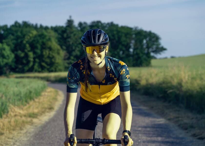 A cyclist smiles while riding along a scenic rural road. A cyclist smiles while riding along a scenic rural road.