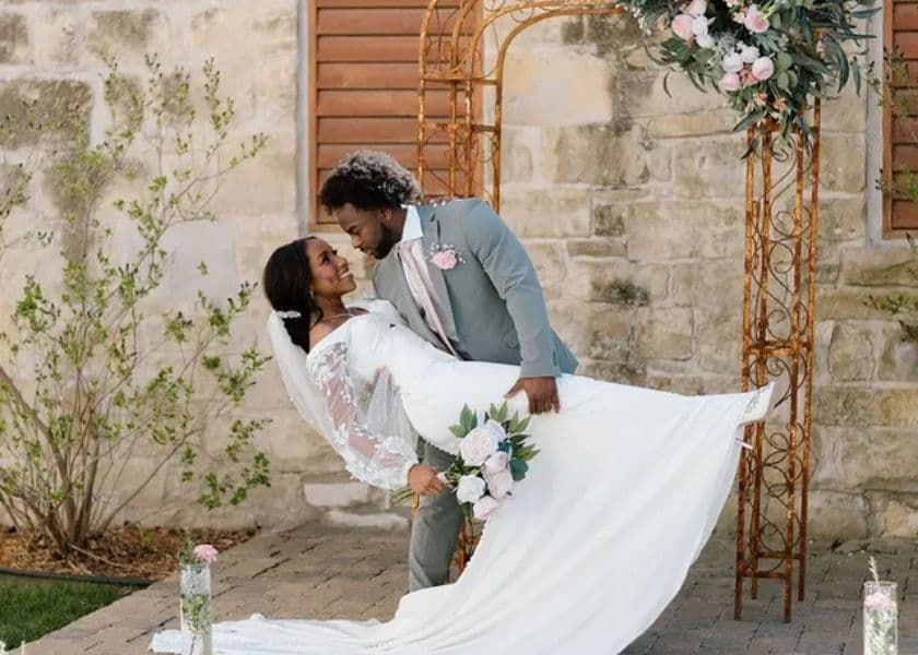 A joyful couple shares an intimate moment during their wedding, with the groom gently dipping the bride under a floral arch. A joyful couple shares an intimate moment during their wedding, with the groom gently dipping the bride under a floral arch.