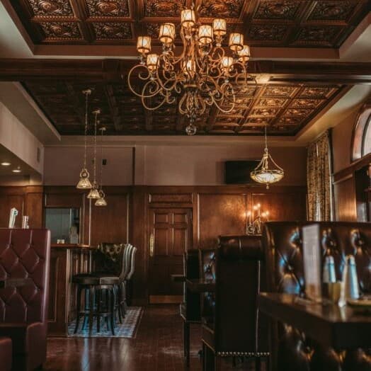 Elegant restaurant interior with wooden accents and ornate chandeliers.