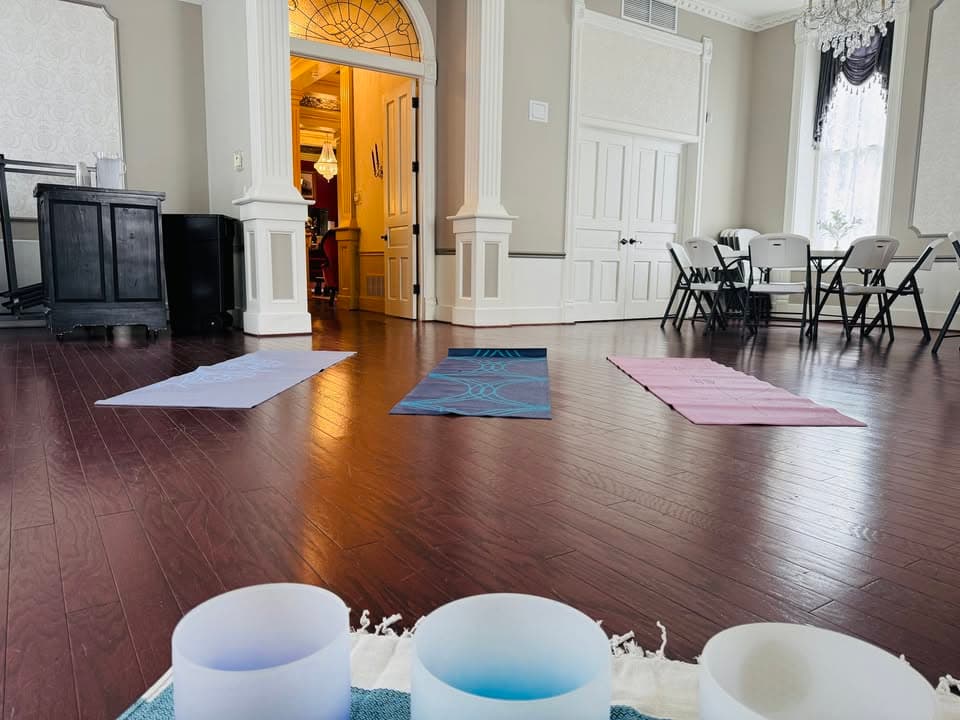 A serene indoor yoga space featuring colorful mats and sound bowls.
